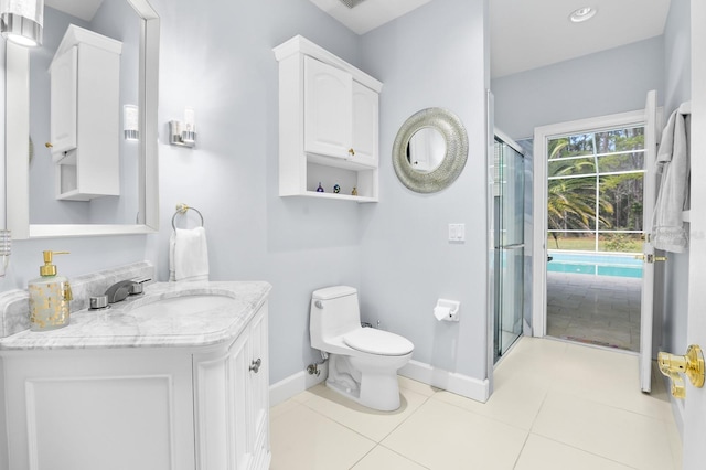 bathroom with tile patterned flooring, toilet, vanity, baseboards, and a shower stall