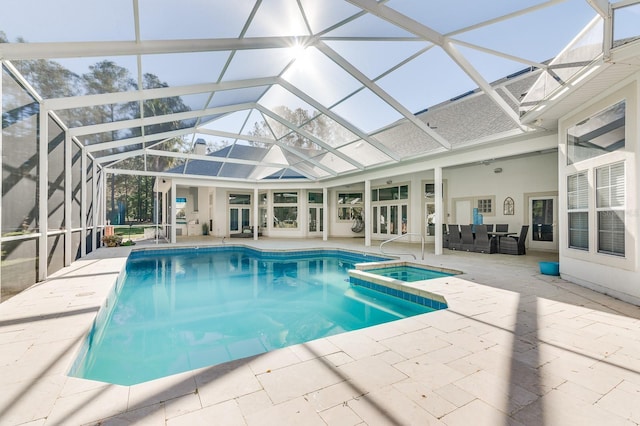 view of swimming pool featuring glass enclosure, a pool with connected hot tub, outdoor lounge area, and a patio