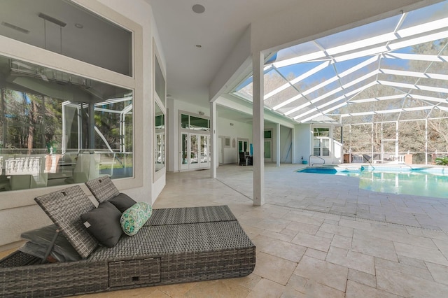 outdoor pool with a lanai, a patio area, and french doors