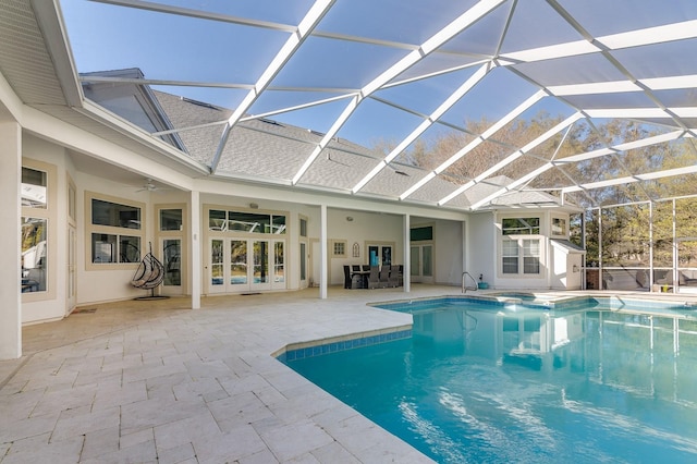 view of pool featuring glass enclosure, a pool with connected hot tub, a patio, and french doors