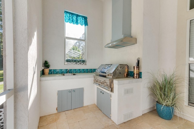 interior space featuring grilling area, an outdoor kitchen, a sink, and visible vents