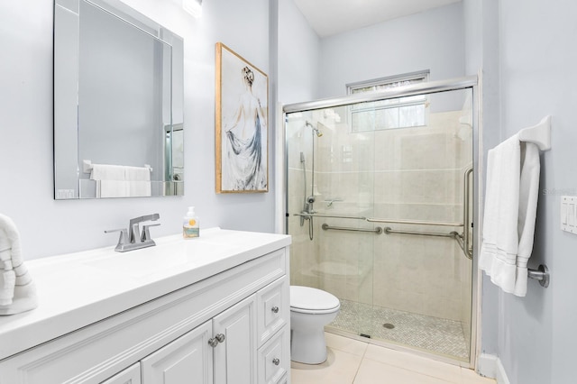 bathroom featuring vanity, a shower stall, toilet, and tile patterned floors