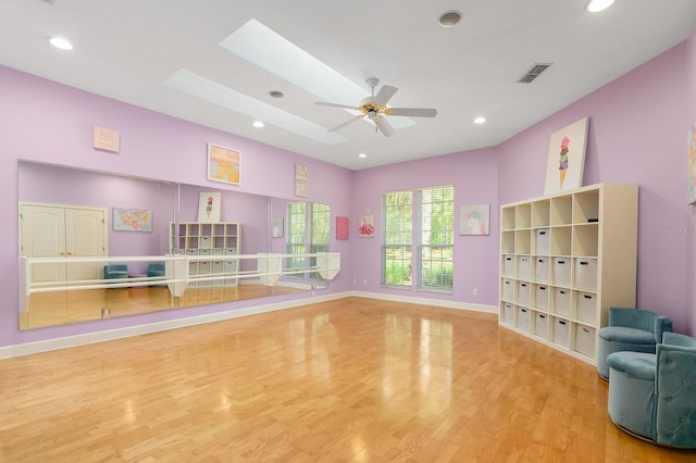 rec room with recessed lighting, a skylight, wood finished floors, visible vents, and baseboards