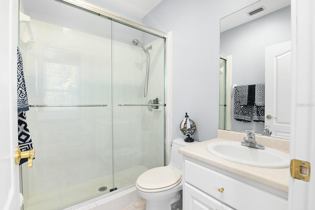 bathroom featuring toilet, a stall shower, visible vents, and vanity