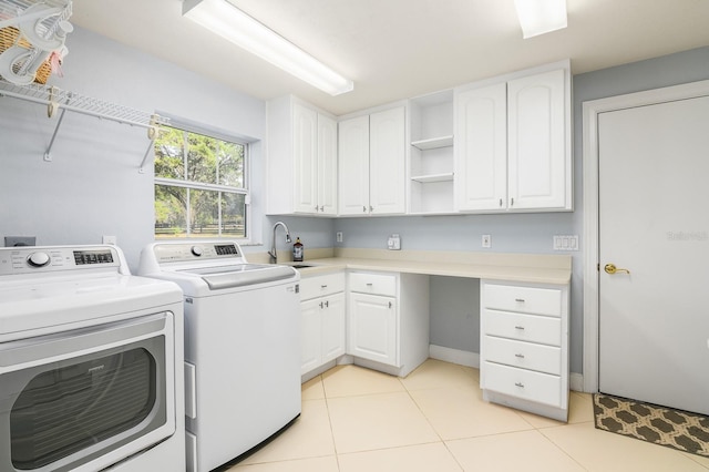 washroom with light tile patterned floors, a sink, cabinet space, and washer and dryer