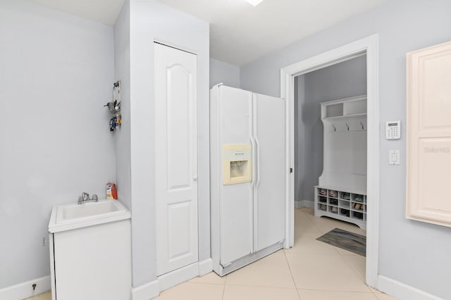 bathroom featuring baseboards, a sink, and tile patterned floors