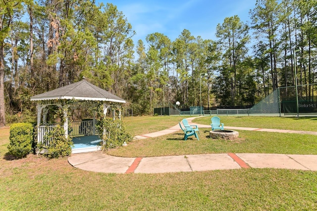 exterior space featuring a fire pit, a gazebo, and fence