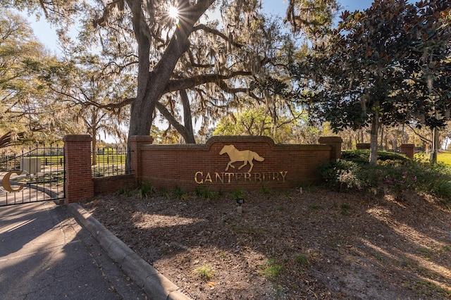 community / neighborhood sign with fence and a gate