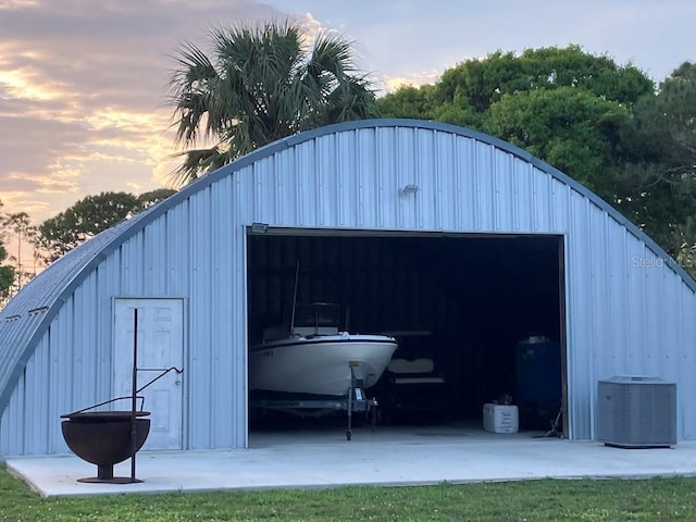 outdoor structure at dusk featuring an outbuilding and central AC unit