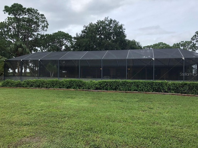 view of tennis court featuring a yard