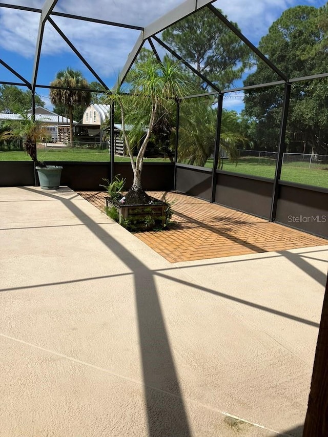 view of patio featuring glass enclosure