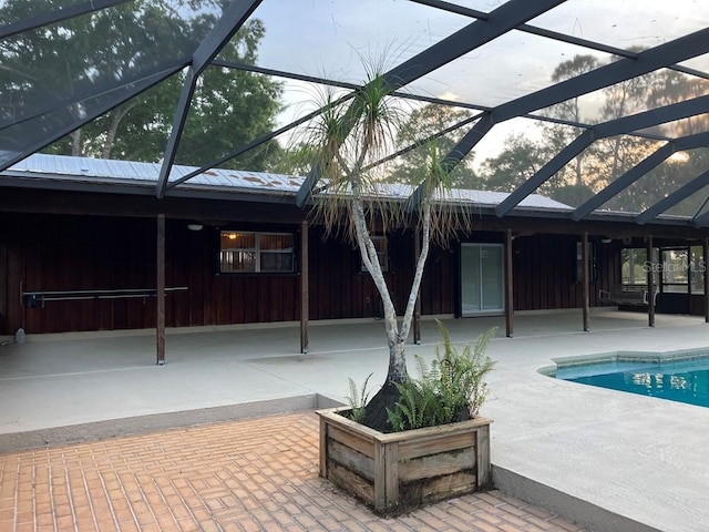 outdoor pool with glass enclosure and a patio