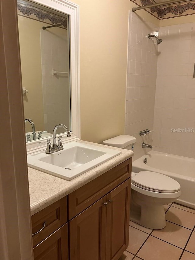 full bathroom featuring washtub / shower combination, vanity, tile patterned flooring, and toilet