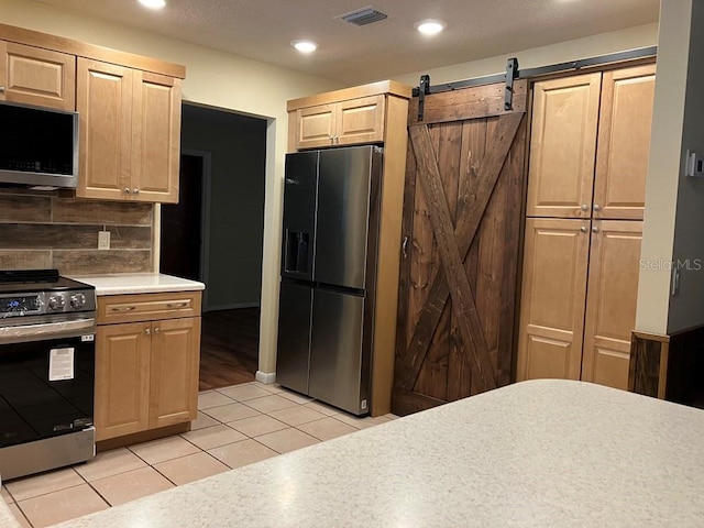 kitchen with visible vents, appliances with stainless steel finishes, light countertops, backsplash, and light tile patterned flooring