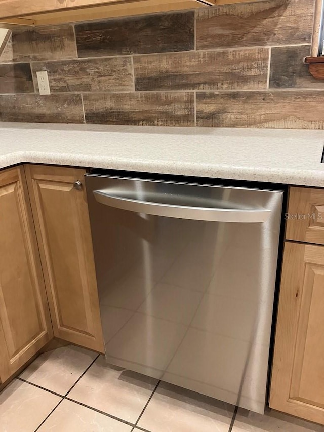 interior details featuring tasteful backsplash, light countertops, and dishwasher