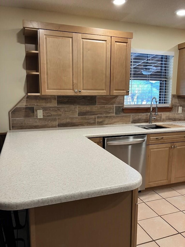 kitchen featuring tasteful backsplash, light countertops, dishwasher, and light brown cabinetry