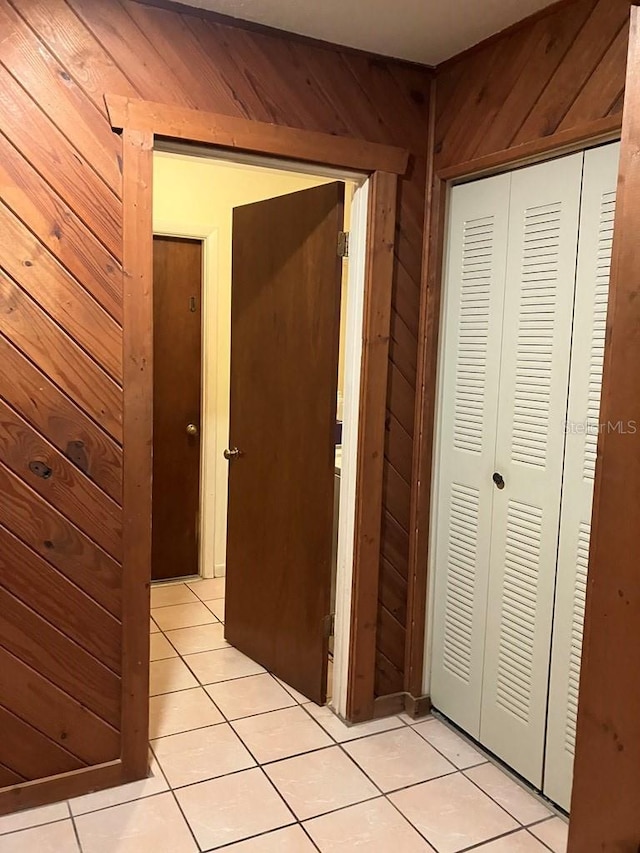 hall featuring wood walls and light tile patterned floors