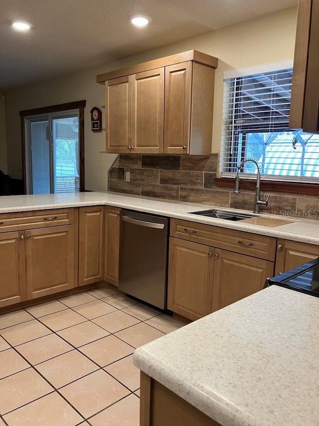 kitchen with dishwasher, light countertops, and a sink