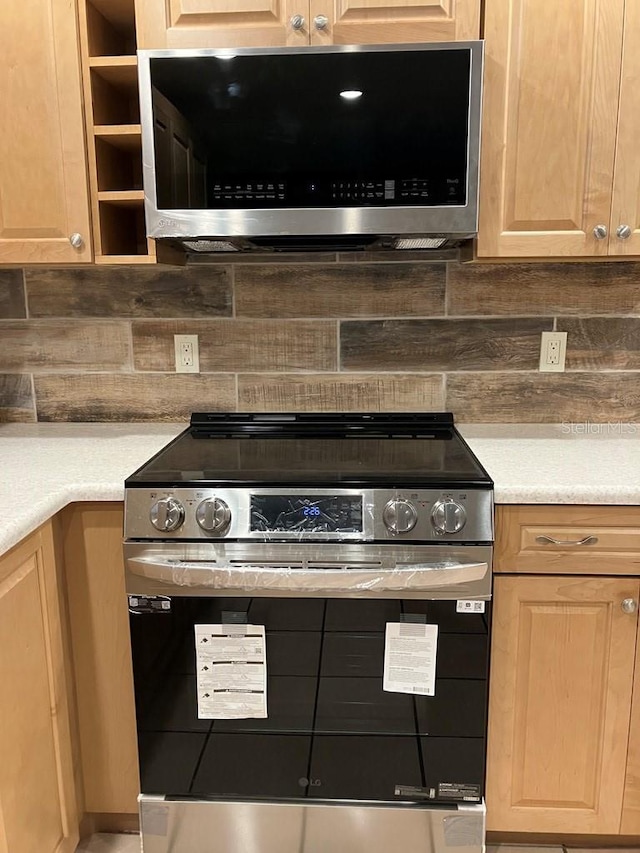 kitchen featuring light brown cabinetry, appliances with stainless steel finishes, and tasteful backsplash