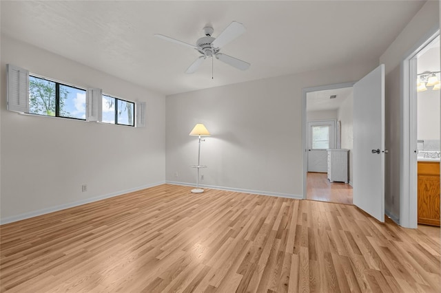 spare room featuring a wealth of natural light, a ceiling fan, light wood-style flooring, and baseboards