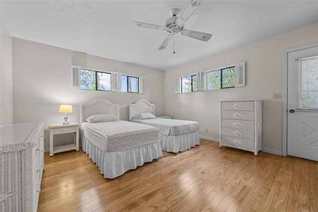 bedroom featuring ceiling fan, light wood finished floors, and baseboards