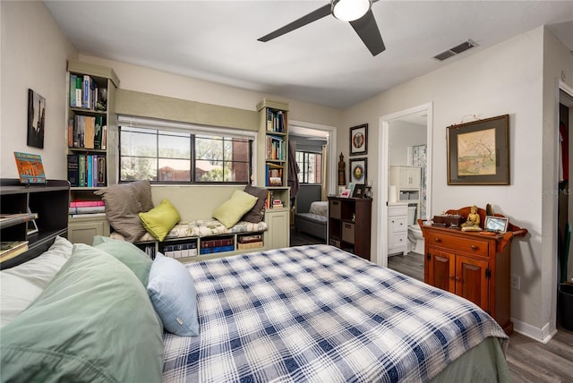 bedroom with dark wood finished floors, visible vents, connected bathroom, ceiling fan, and baseboards