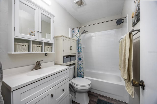 full bathroom with toilet, shower / tub combo, wood finished floors, vanity, and visible vents