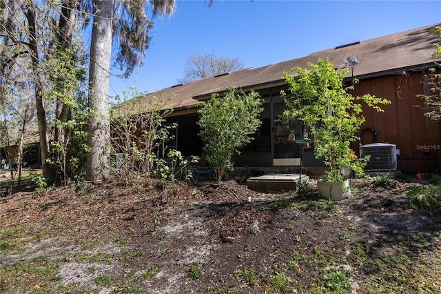 rear view of house featuring central AC and a sunroom