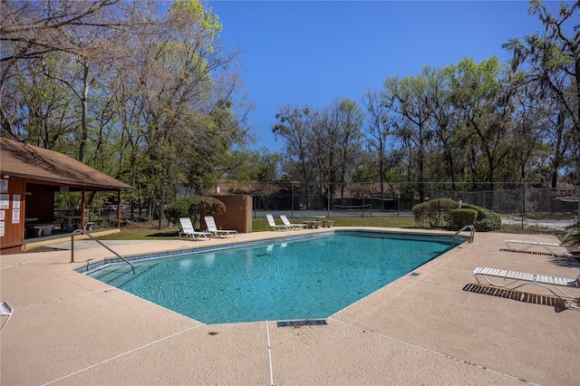 pool with a patio and fence