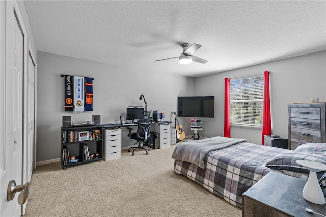 carpeted bedroom with ceiling fan and a textured ceiling