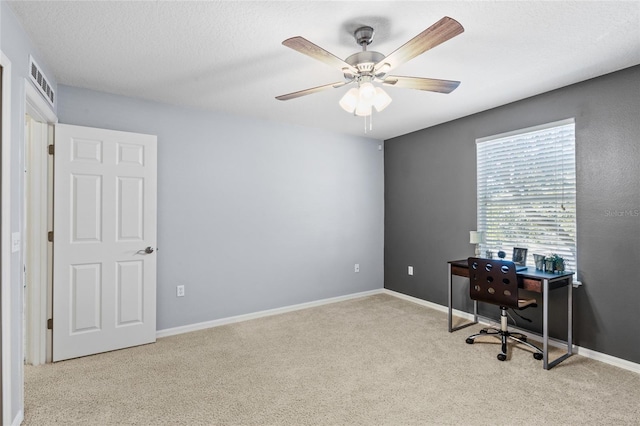 carpeted home office featuring baseboards, visible vents, and a ceiling fan