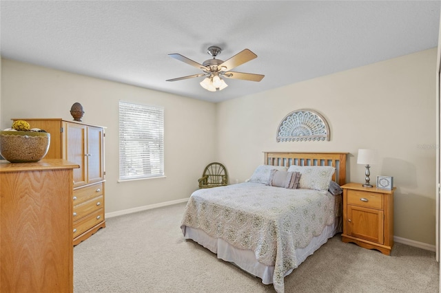 bedroom with light carpet, ceiling fan, and baseboards