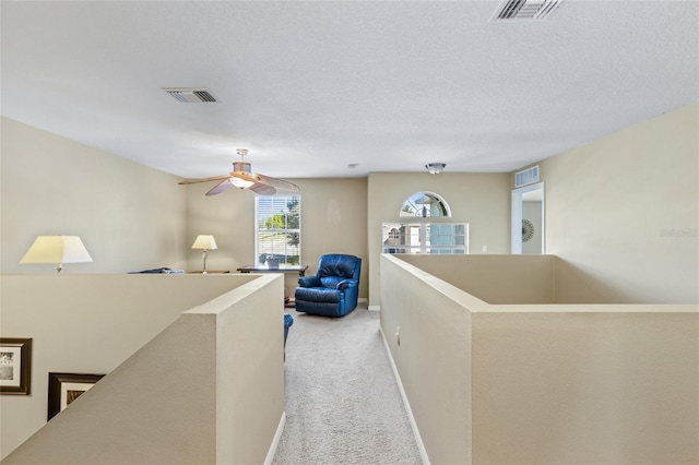 corridor with visible vents, light colored carpet, and an upstairs landing