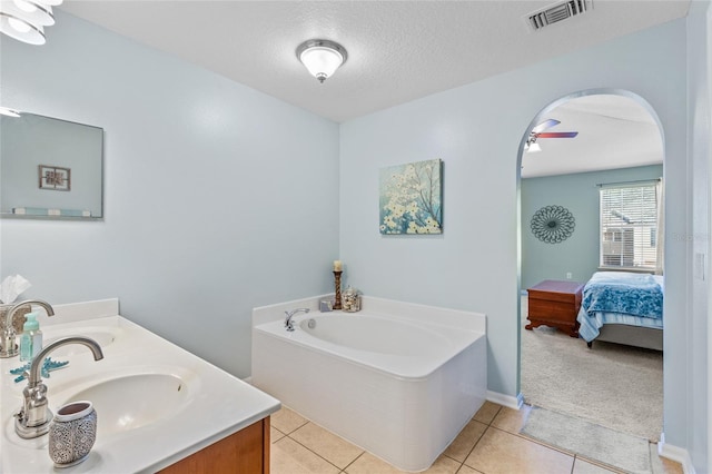 full bath with a textured ceiling, a garden tub, tile patterned flooring, a sink, and visible vents