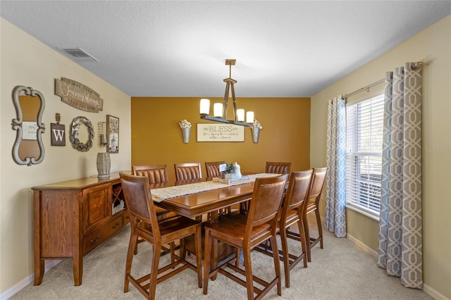 dining area with visible vents, light carpet, a textured ceiling, a chandelier, and baseboards