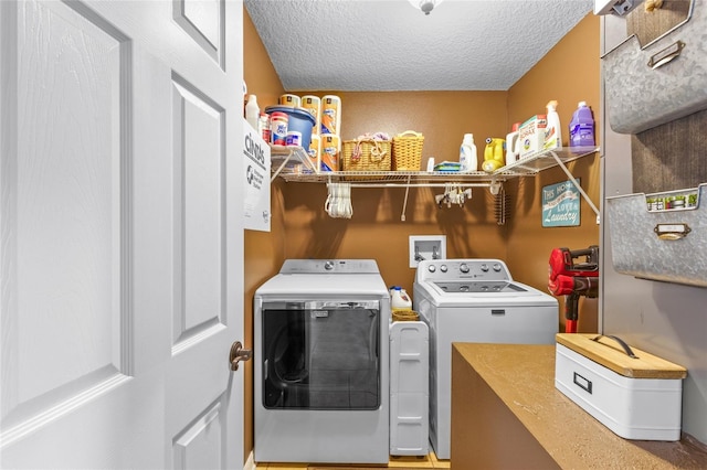 washroom featuring a textured ceiling, laundry area, and separate washer and dryer