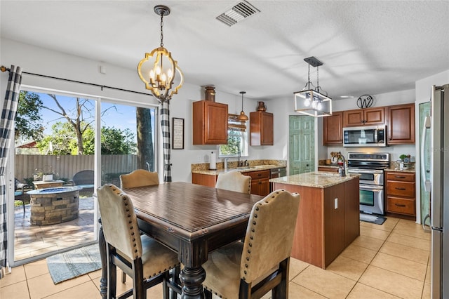 dining room featuring light tile patterned floors, a notable chandelier, visible vents, and a textured ceiling