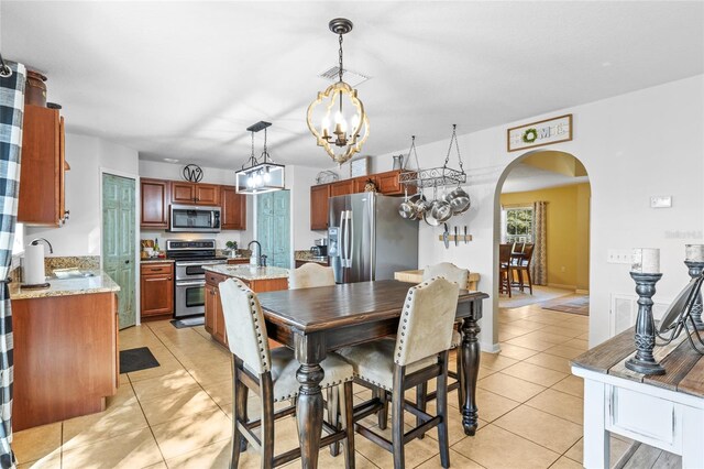 dining space with an inviting chandelier, visible vents, arched walkways, and light tile patterned flooring