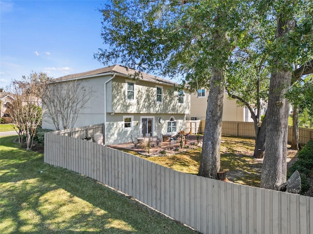 exterior space featuring a yard, fence, and stucco siding