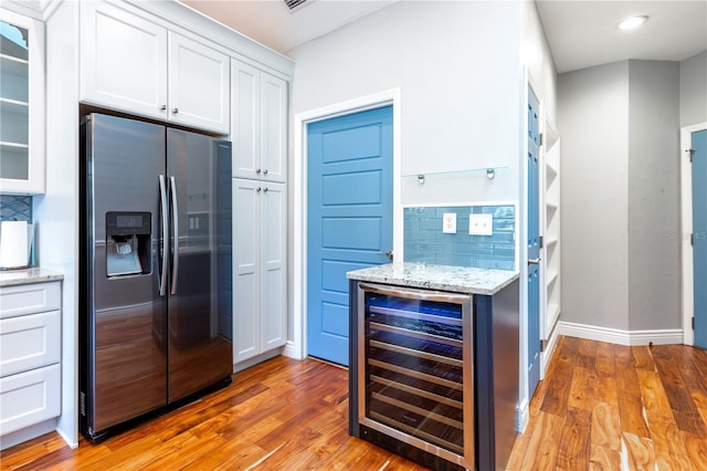 kitchen featuring white cabinets, wine cooler, light wood-style floors, stainless steel refrigerator with ice dispenser, and backsplash
