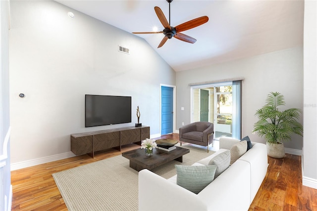 living area featuring visible vents, a ceiling fan, wood finished floors, high vaulted ceiling, and baseboards