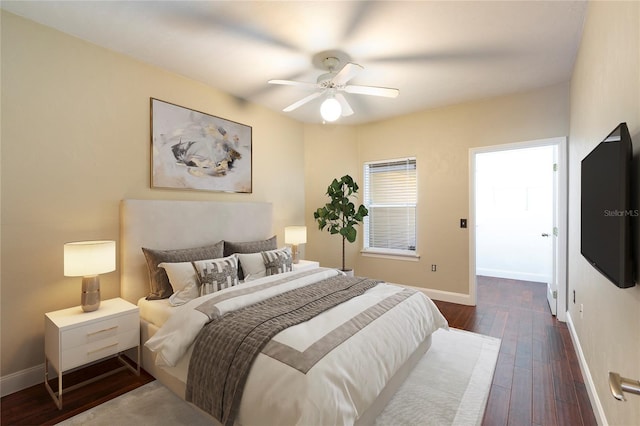 bedroom featuring baseboards, dark wood finished floors, and a ceiling fan