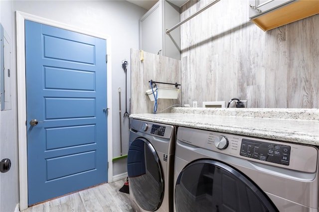 washroom with cabinet space, washer and clothes dryer, and wood finished floors