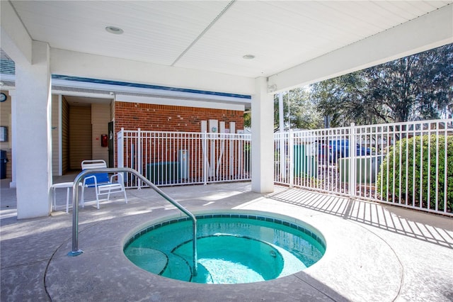 view of swimming pool with a patio area, fence, and a hot tub