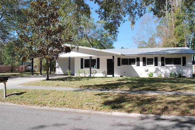 ranch-style home featuring a front yard, a carport, driveway, and stucco siding