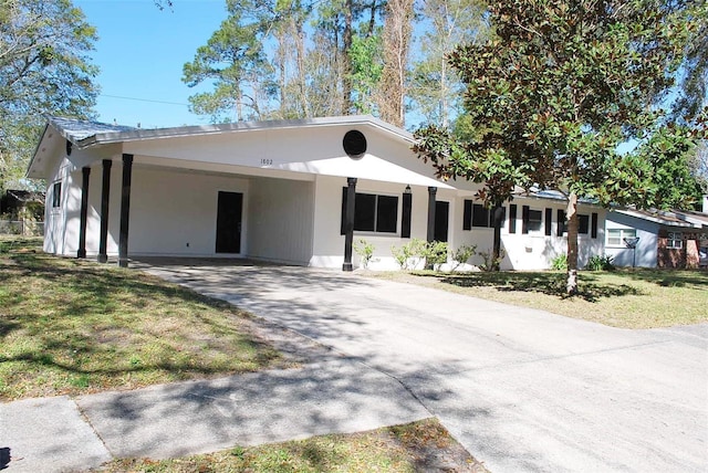 single story home with concrete driveway and a front lawn