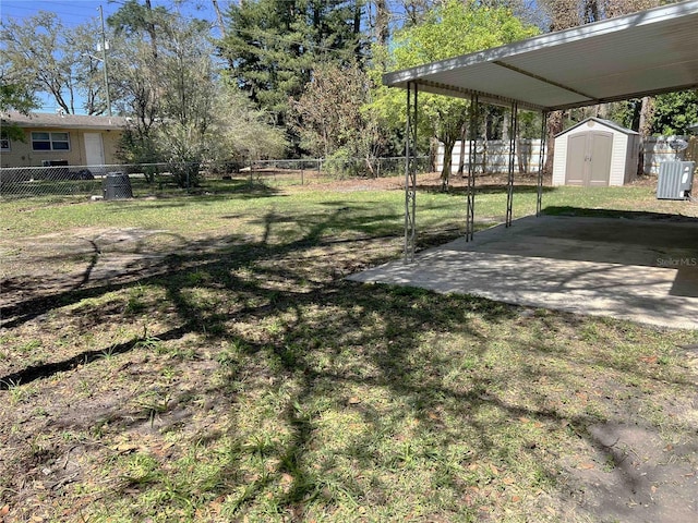 view of yard with an outbuilding, a patio, a fenced backyard, a storage shed, and a detached carport