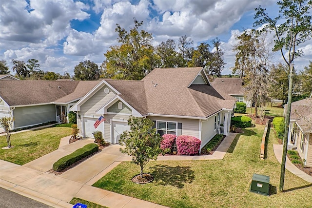 view of front facade featuring a garage, a front yard, driveway, and a shingled roof