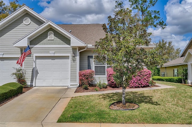 view of front of home with an attached garage, driveway, a front lawn, and roof with shingles