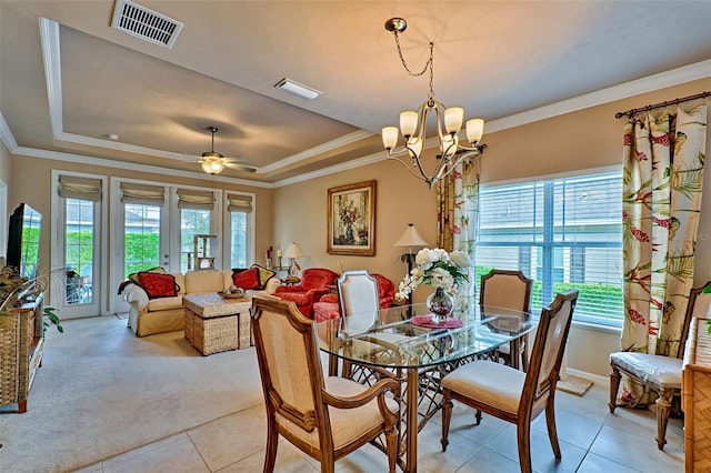 dining space with ornamental molding, a tray ceiling, and visible vents